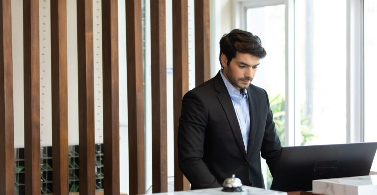 Friendly handsome man hotel receptionist in a stylish luxury hot